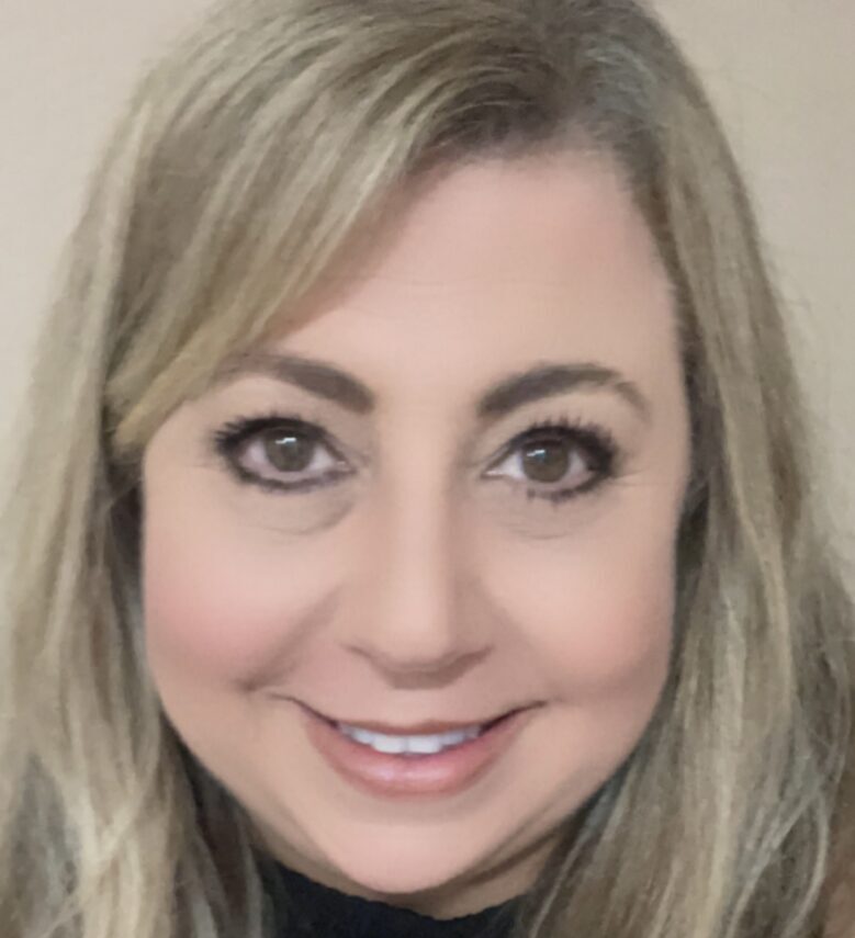 Smiling person with long blonde hair.