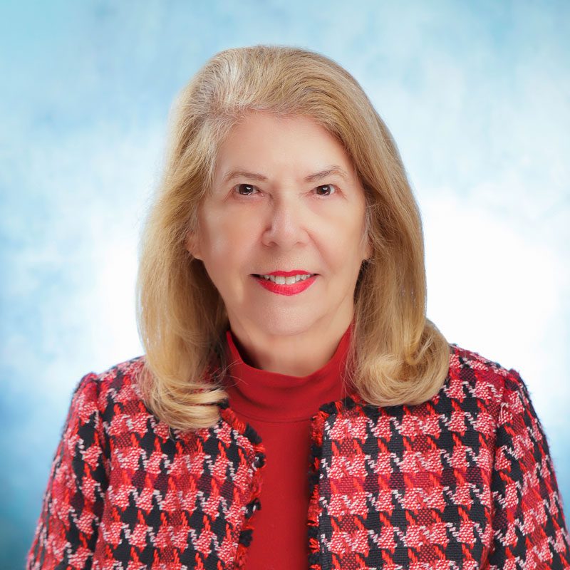 Smiling woman in red checkered jacket.