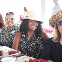 Group of women smiling at outdoor event.
