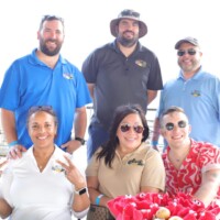 Group of people smiling at outdoor event.