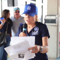 Woman speaking into microphone at event.