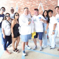 Group of people posing, smiling at event.