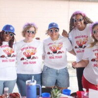 Group of women posing in themed shirts.