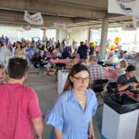 People enjoying a community event with tables.