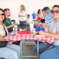 People enjoying a meal at outdoor event.