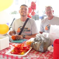 Two men at a festive food table.