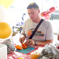 Man slicing pepper at a festive event.