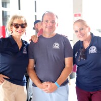 Three people smiling at a casual event.