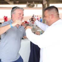 Two men laughing and playfully interacting indoors.