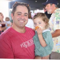 Man holding child eating a snack.