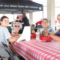 People smiling at a table with food.