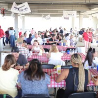 People eating at a crowded indoor event.