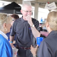 People talking and laughing at outdoor event.