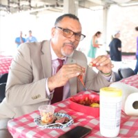 Man eating crawfish at a picnic table.