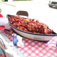 Boat-shaped dish filled with crawfish and lemons.