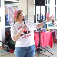 Woman speaking into microphone at event.