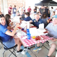 People enjoying food at outdoor gathering.