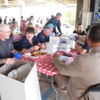 People eating at a red-checkered table.