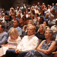 Audience seated in a crowded auditorium.