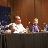 Panelists seated at a discussion table, smiling.