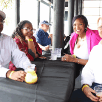 Four people smiling at a table.