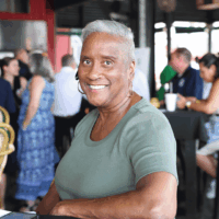 Smiling woman sitting at a crowded event.