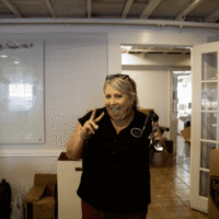 Smiling woman flashing peace sign indoors